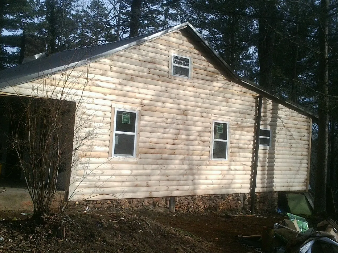 New log siding and dark metal roofing on a gable end in Middletown